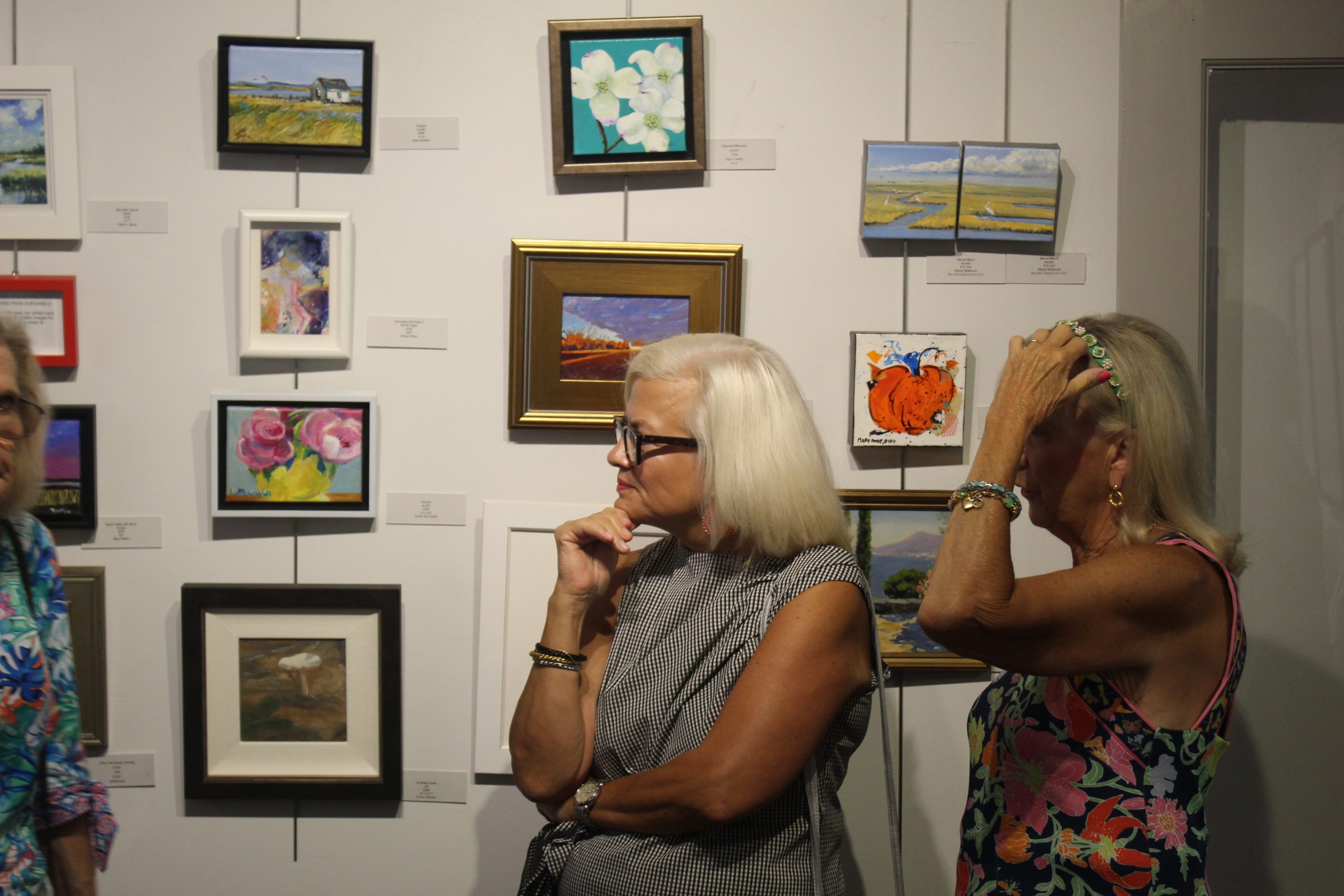 Two women looking at paintings at the Bethany Beach Boardwalk Arts Festival